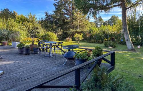 Munkerupにある3 Bedroom Amazing Home In Gillelejeの庭園内の木製デッキ(テーブル、椅子付)