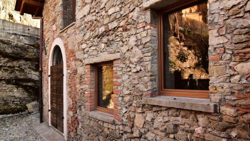 a stone building with two windows on the side of it at Il Ronchetto in Cunardo
