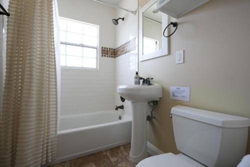 a bathroom with a sink and a toilet and a tub at Destination #11 in Anaheim