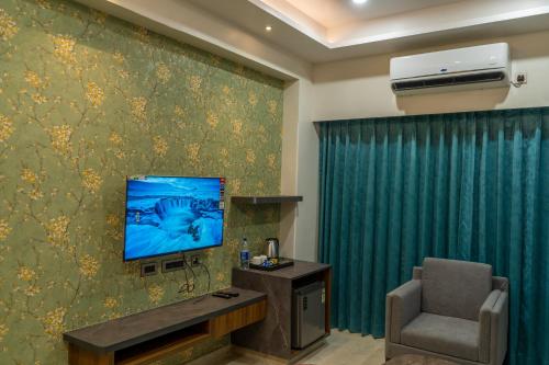 a room with a tv and a chair in a room at Hotel K Fortune in Kurnool