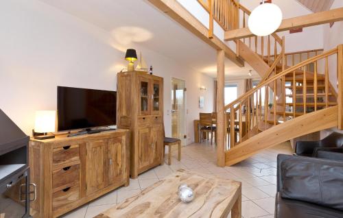 - un salon avec une télévision à écran plat dans un centre de divertissement en bois dans l'établissement Cozy Apartment In Rechlin With Sauna, à Zielow