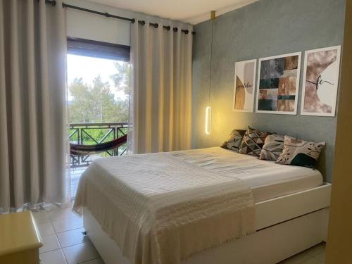 ein Schlafzimmer mit einem Bett und einem Balkon in der Unterkunft Gravatá Flat no condomínio Monte Castelo MELHOR LOCALIZAÇÃO , Wi-Fi, SKY e AR in Gravatá