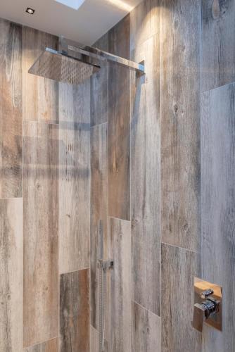 a bathroom with a wooden wall with a shower at Borgo Rotondo in San Giovanni in Persiceto