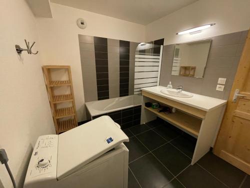 a bathroom with a sink and a bath tub at ALTURA T2 Duplex wifi au pied des montagnes in Le Lioran