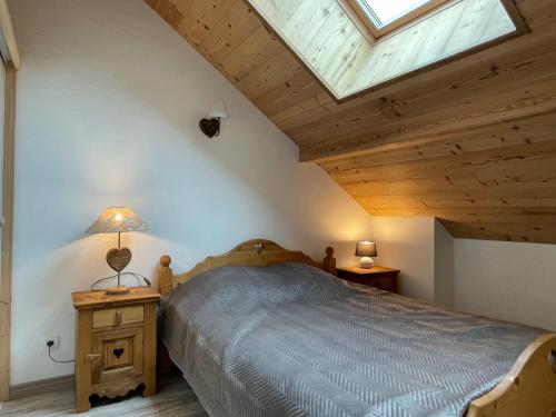 a bedroom with a bed and a skylight at ALTURA T2 Duplex wifi au pied des montagnes in Le Lioran