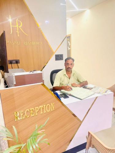 a man sitting at a table in an office at Hasrat Residency in Jagādhri