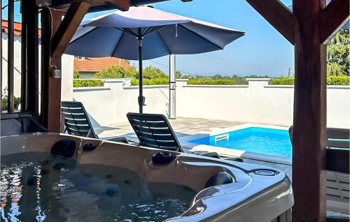 bañera de hidromasaje con 2 sillas y sombrilla en Nice Home In Kutina, en Brinjani