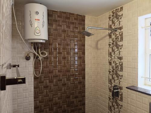 a bathroom with a shower with a light on the wall at Hillcrest Metro in Ooty