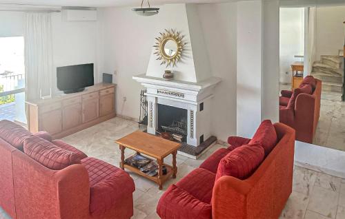 a living room with red couches and a fireplace at 3 Bedroom Cozy Home In Fuengirola in Torremuelle
