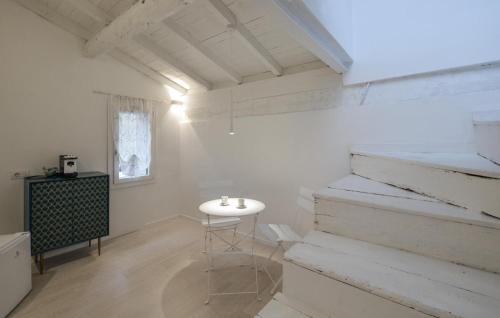 Habitación blanca con mesa blanca y escaleras en Paradiso, en Pieve di Teco