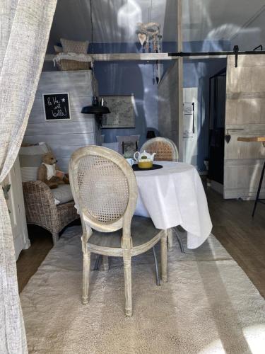 une table à manger avec deux chaises et une nappe blanche dans l'établissement Le Studio de Sosso, à Aniane