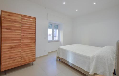ein Schlafzimmer mit einem Bett und einer Holzkommode in der Unterkunft Stunning Apartment In Santa Maria Di Castellabate in Santa Maria di Castellabate