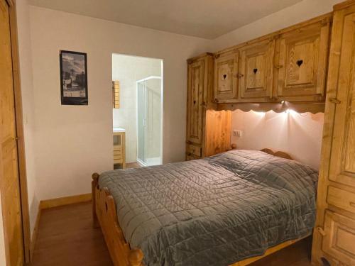 um quarto com uma cama e armários de madeira em Rocher du Cerf skis aux pieds 3 ch 2 sdb em Le Lioran