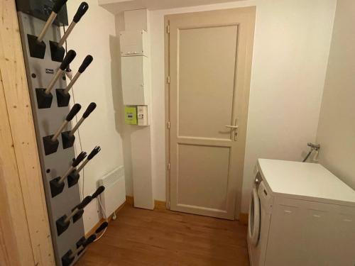 uma cozinha com uma porta e um suporte de tacos de beisebol em Rocher du Cerf skis aux pieds 3 ch 2 sdb em Le Lioran