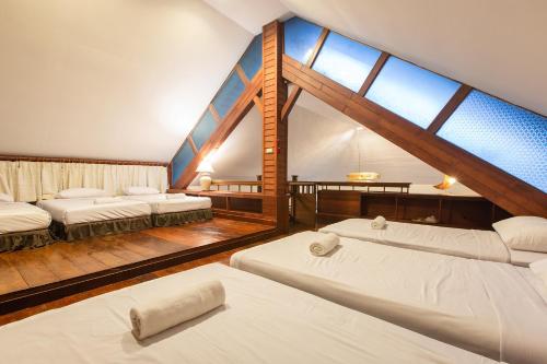 a room with three beds and a large window at ปานเทล เขาใหญ่ Parntel KhaoYai in Khao Yai