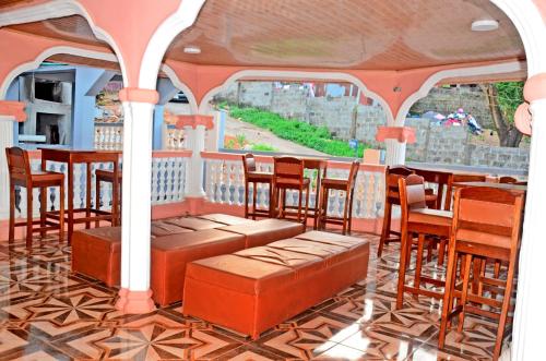 a gazebo with chairs and tables and a bar at Elevation Lodge Imatt in Freetown