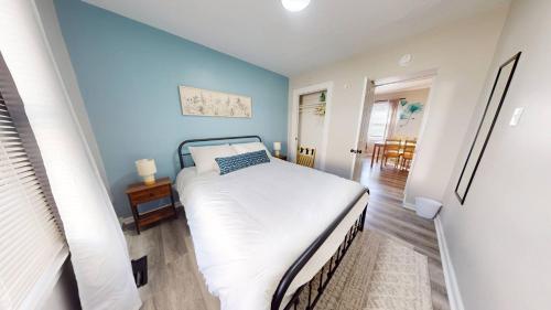 a bedroom with a white bed and blue walls at 3 Bed 2 bath Pet Friendly in Historic Bates Hendricks in Indianapolis