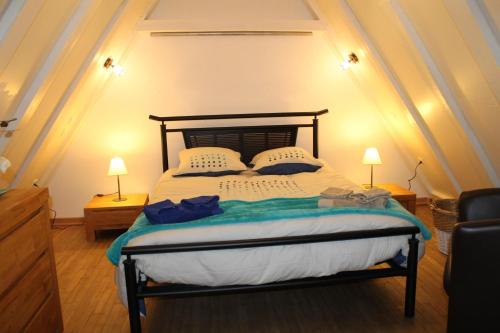 a bedroom with a large bed with two lamps at Les Combes avec piscine chauffée au nord Sarlat in LʼAir