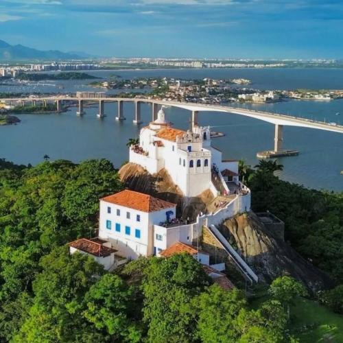 a castle on a hill with a bridge in the background at Apart Moderno Proximo ao Mar in Vila Velha