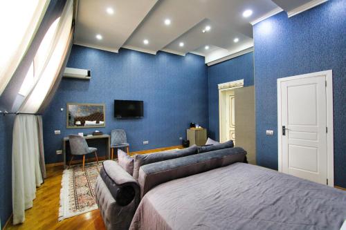 a bedroom with blue walls and a bed and a desk at Pilot By Haz Hotel in Baku
