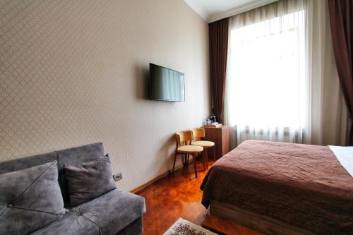 a hotel room with a bed and a couch at Pilot By Haz Hotel in Baku