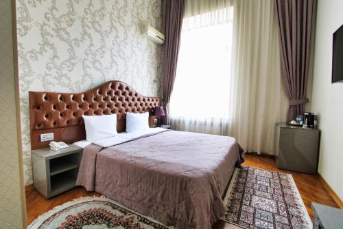 a bedroom with a large bed with a large window at Pilot By Haz Hotel in Baku