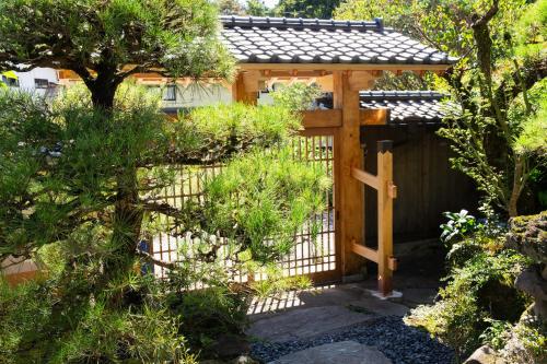 a wooden gazebo in the middle of a garden at 春日光 HaruNikko Guesthouse - Traditional Japanese Guesthouse with Japanese Garden in Nikko