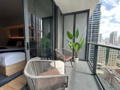 a bedroom with a bed and chair on a balcony at NEW luxury suite Miami at the WorldCenter area - Great views in Miami