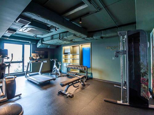 a gym with a treadmill and a bench in a room at Mercure Bialystok in Białystok