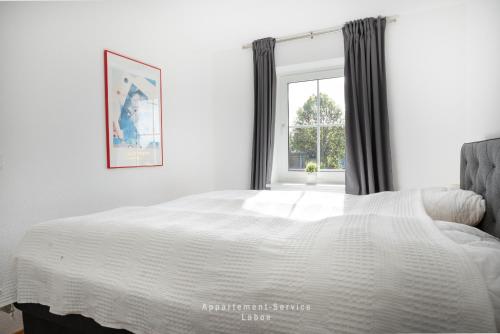 a bedroom with a white bed and a window at Nautic W13 in Laboe
