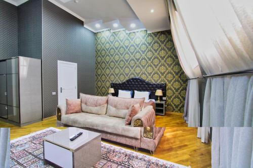 a living room with a couch and a table at Pilot By Haz Hotel in Baku