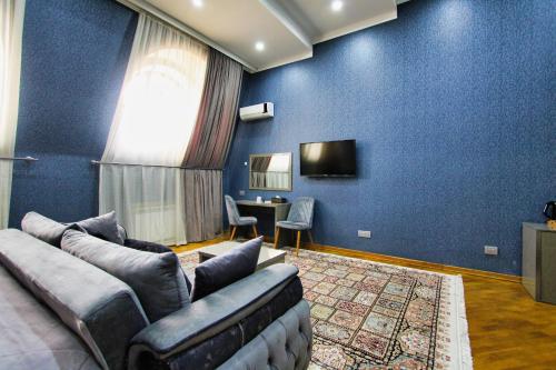 a blue living room with a couch and a tv at Pilot By Haz Hotel in Baku