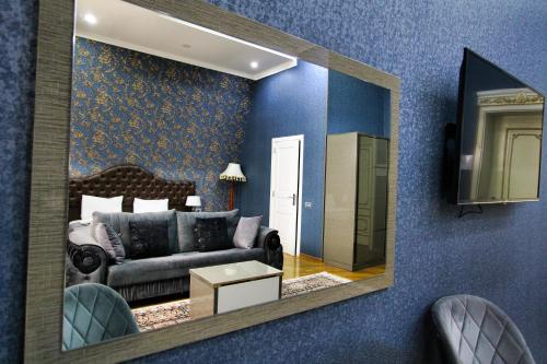 a living room with a mirror and a couch at Pilot By Haz Hotel in Baku