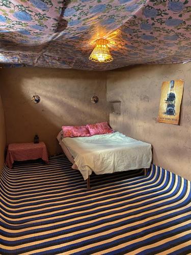 a bedroom with a bed and a painted ceiling at Dar Nomad Tagounite in Zagora