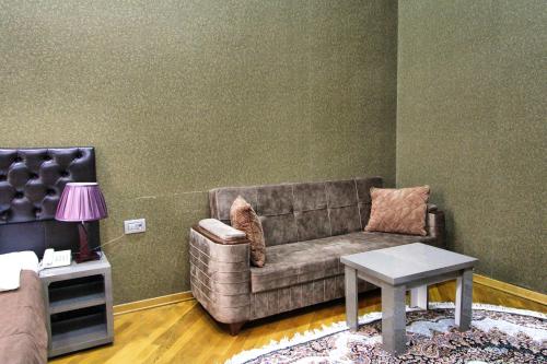 a living room with a couch and a table at Pilot By Haz Hotel in Baku