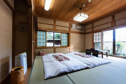a bedroom with a large bed in a room with windows at 春日光 HaruNikko in Nikko