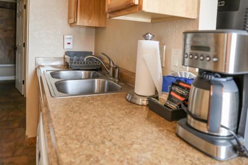 a kitchen counter with a sink and a coffee maker at Yellowstone Gateway Inn in Gardiner