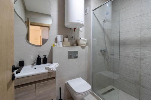 ein Badezimmer mit Dusche, Toilette und Waschbecken in der Unterkunft Studio chic et paisible avec piscine parc et plage in Aïn Harrouda