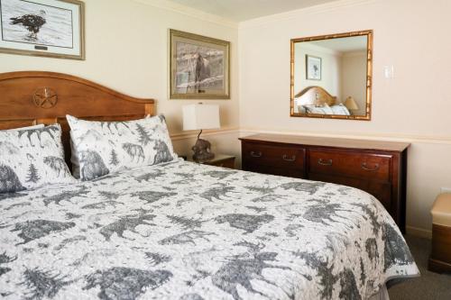 a bedroom with a large bed and a mirror at Yellowstone Gateway Inn in Gardiner