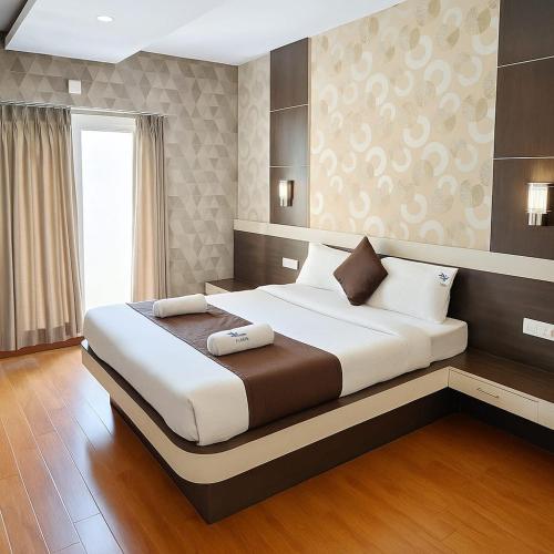 Un dormitorio con una cama grande en una habitación. en The Majestic Crown, en Ooty