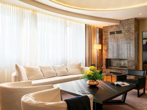 a living room with a couch and a table at BERDS Hotel Chisinau - MGallery Collection in Chişinău
