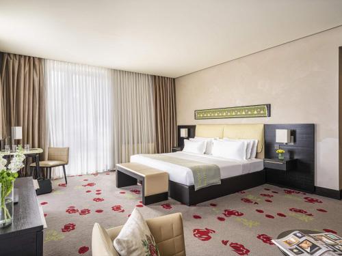 a large hotel room with a bed and a desk at BERDS Hotel Chisinau - MGallery Collection in Chişinău