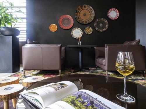 a living room with a couch and a glass of wine at BERDS Hotel Chisinau - MGallery Collection in Chişinău