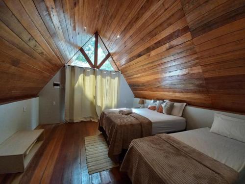 a bedroom with two beds and a wooden ceiling at Pousada Raízes Cotijuba in Belém