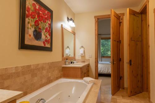 een grote badkamer met een bad en een wastafel bij Angani Way Townhome 104 in Elkhorn Village