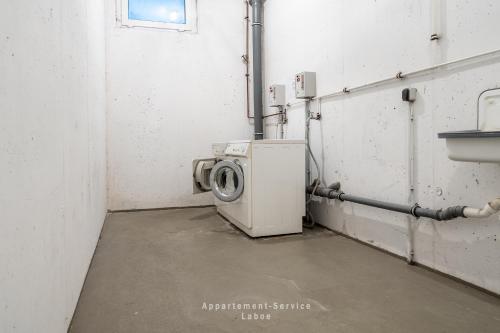a laundry room with a washing machine and a sink at Nautic W08 in Laboe