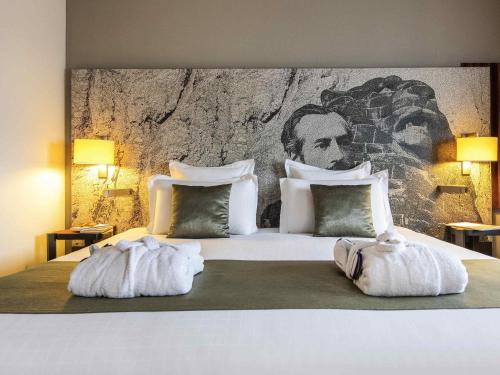 a bedroom with a large bed with two towels at Mercure Belfort Centre in Belfort