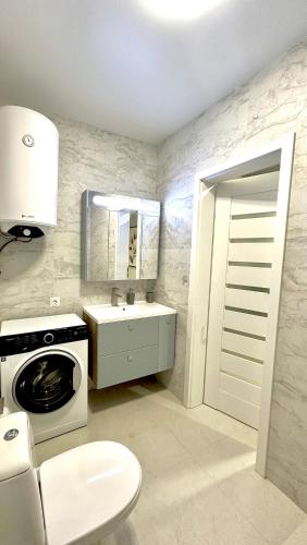 a kitchen with a sink and a washing machine at City Apartments in Ivano-Frankivsʼk