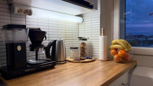 una encimera de cocina con cafetera y fruta. en Viihtyisä kaksio keskustassa, en Kokkola