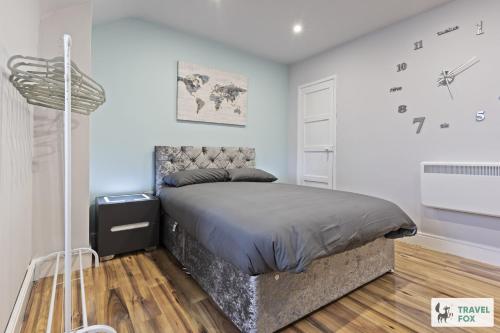 a bedroom with a bed and a clock on the wall at Bella's House 12mins bus to Motor Point Arena Free Street Parking in Nottingham